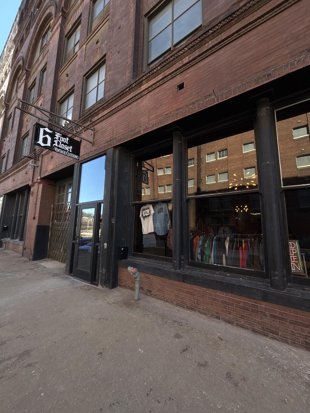 The 6 Foot Closet shopfront with its neon OPEN sign and window display of hanging garments