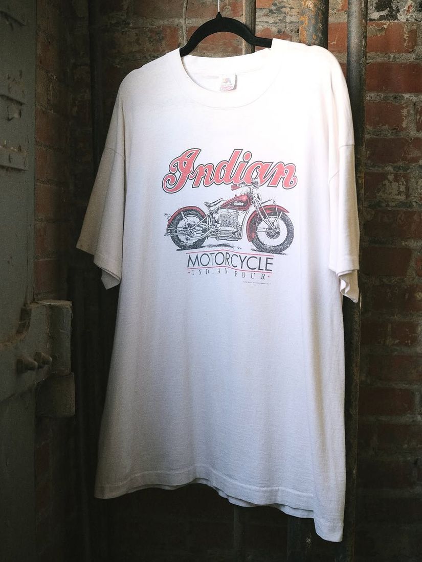 A vintage Indian Motorcycle tee shirt on a hanger against the painted brick wall at 6 Foot Closet